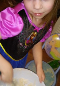Pre-K child wears a FROZEN dress ( Disney registered character) at her Tinker Bell (Disney resgistered caharacter ) table and chair.)